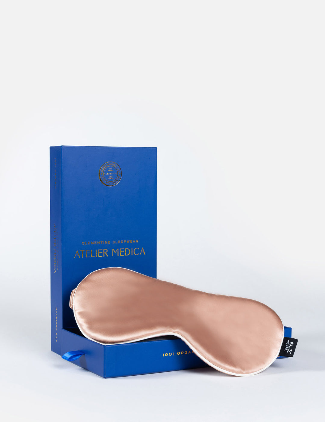 Silk sleep mask in front of a blue box labeled "Clementine Sleepwear ATELIER MEDICA"