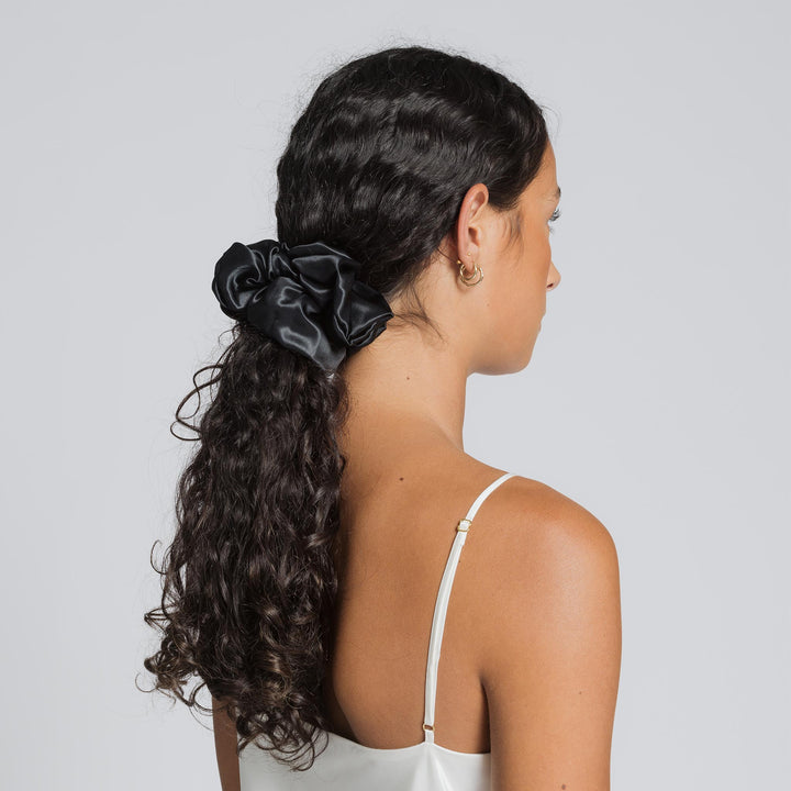 Black silk scrunchie securing a low ponytail