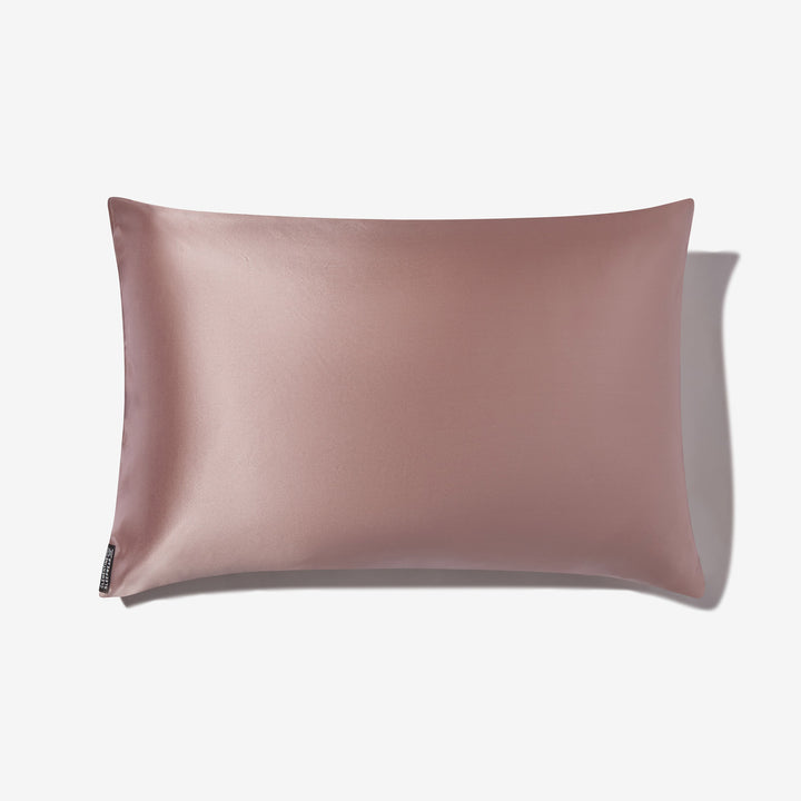 Rose-mist silk pillowcase, rectangular, front view with small black brand tag at lower-left. - #color_rose-mist