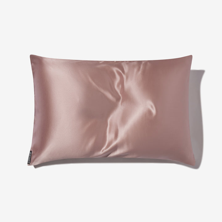 rose-mist silk pillowcase with smooth silk sheen and small black brand tag at lower-left - #color_rose-mist