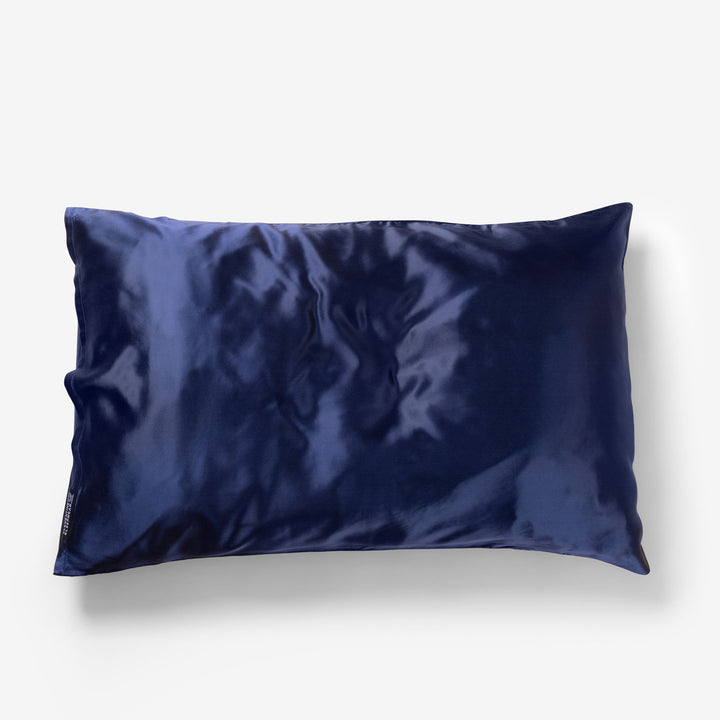 Navy blue silk pillowcase with subtle sheen on a white background - #color_navy-blue