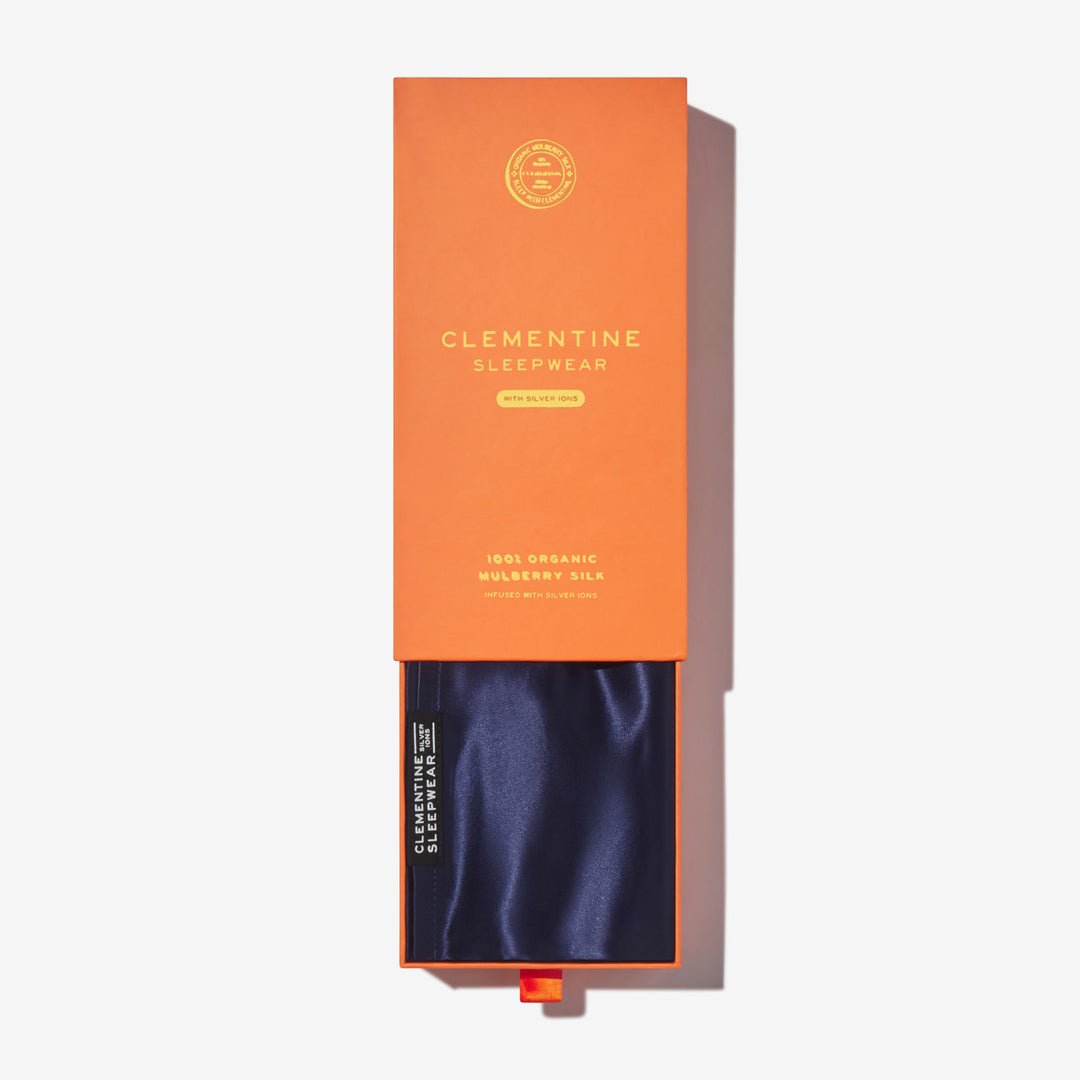 Orange box labeled CLEMENTINE SLEEPWEAR; navy silk drawer. Visible text: WITH SILVER IONS; 100% ORGANIC MULBERRY SILK#color_navy-blue