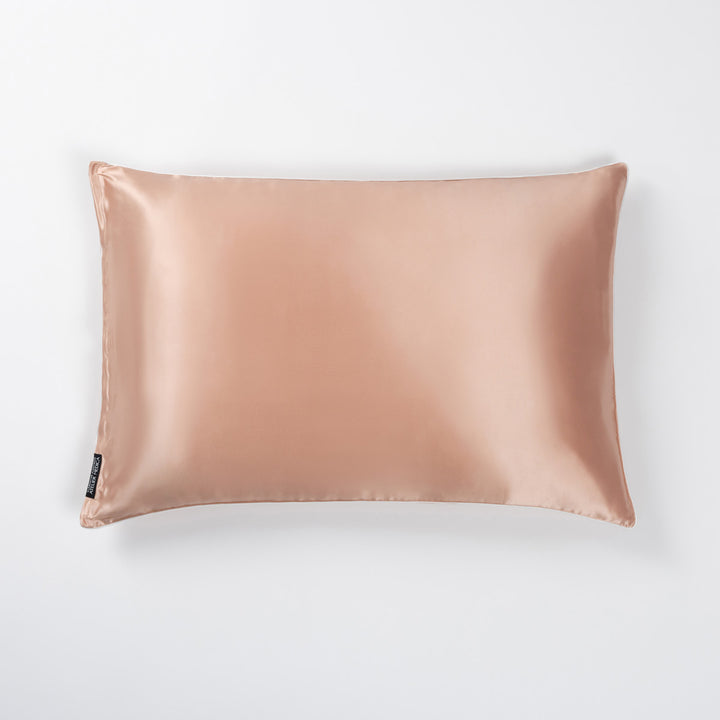 Clementine-peach silk pillowcase with stitched edges and small black brand tag on corner - #color_clementine-peach