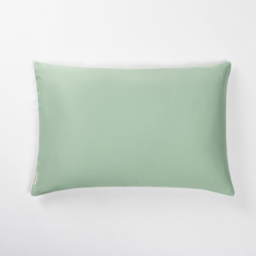 Green rectangular pillow with a small fabric tag on the left side#color_match-point-green