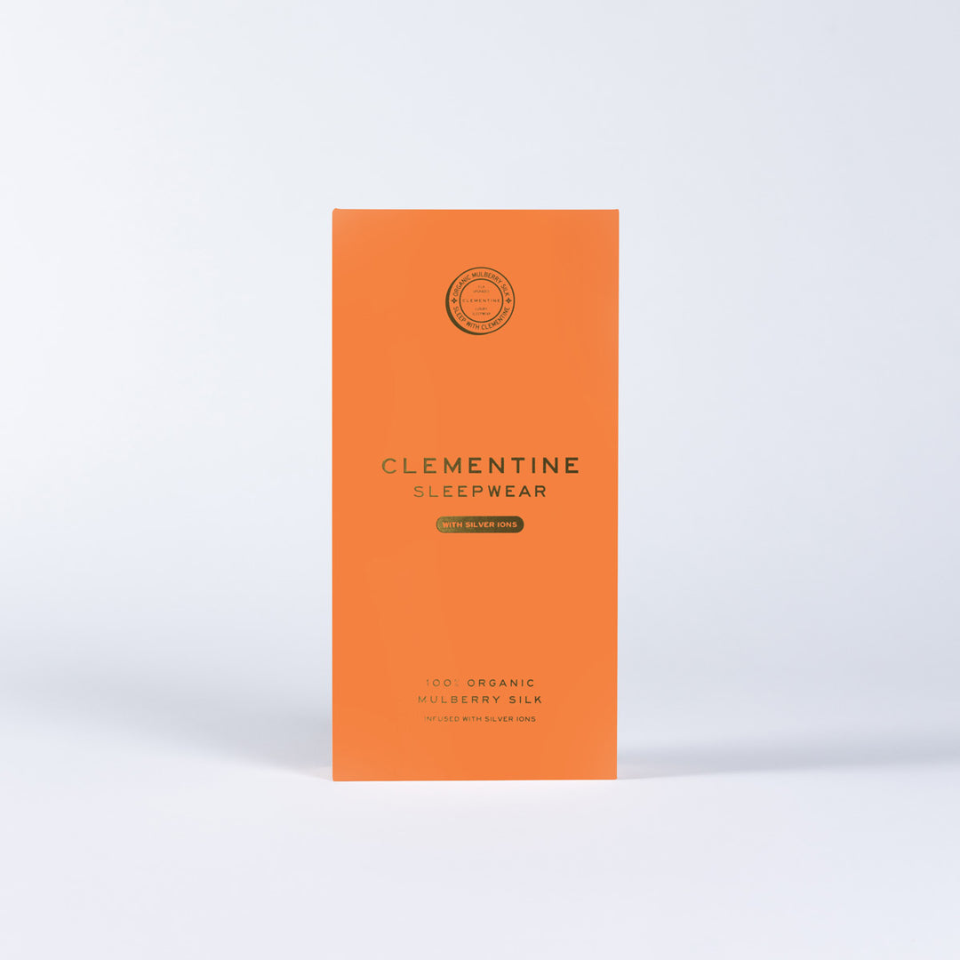 Orange packaging panel reading 'CLEMENTINE SLEEPWEAR' with 'WITH SILVER IONS' and '100% ORGANIC MULBERRY SILK'. - #color_navy-blue