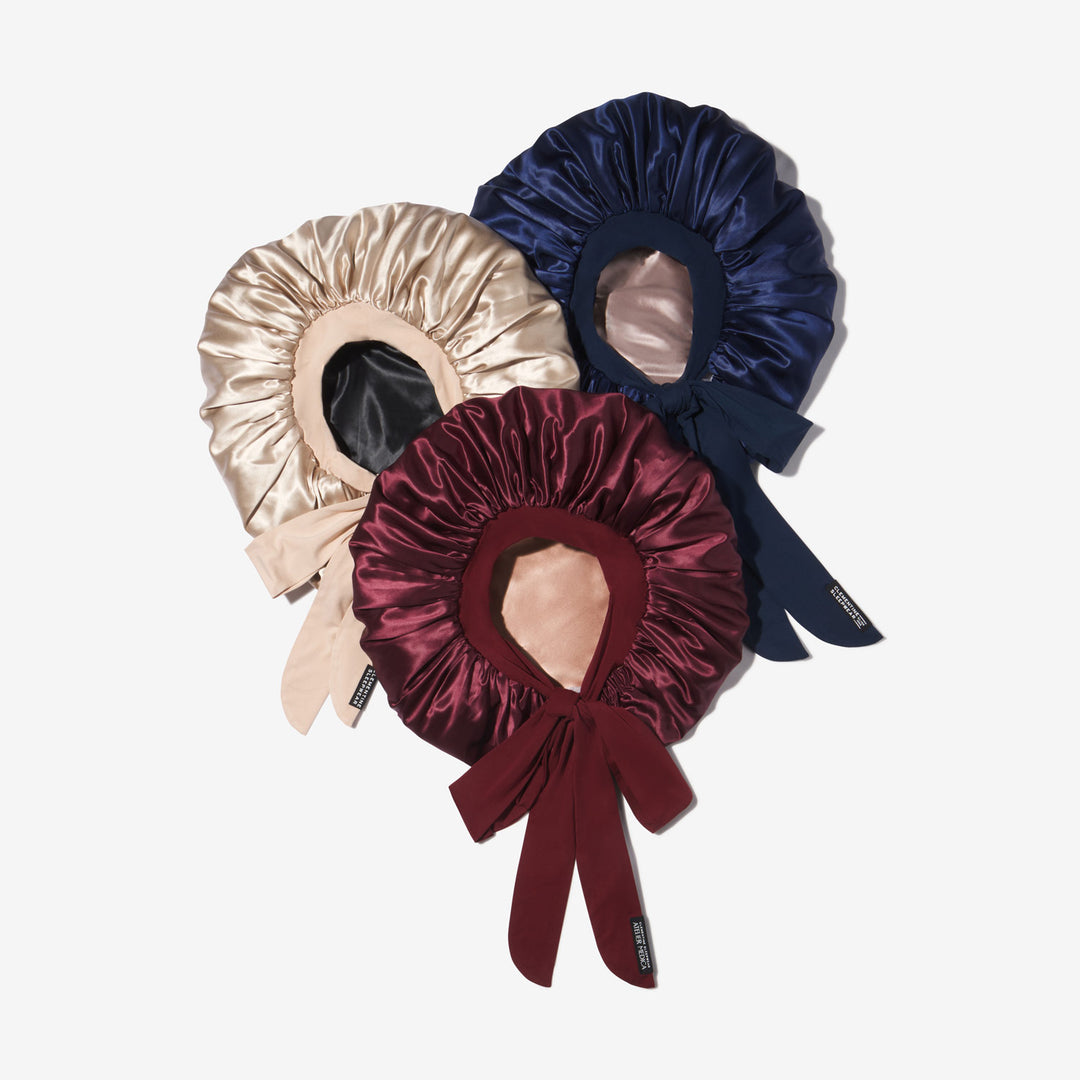 Three XL satin sleep bonnets with long ties in burgundy, navy, and champagne