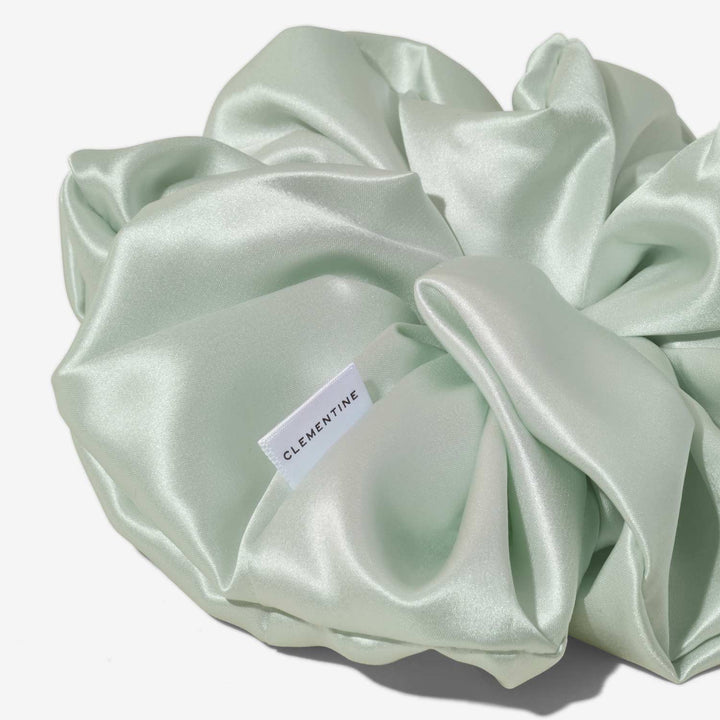 Large mint silk hair scrunchie showing CLEMENTINE fabric brand tag