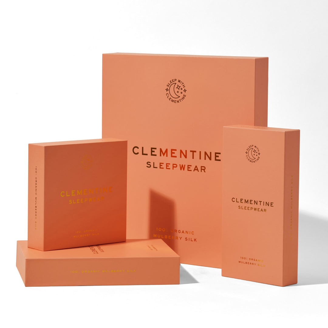 Three coral product boxes labeled 'CLEMENTINE SLEEPWEAR', 'SLEEP WITH CLEMENTINE', and '100% ORGANIC MULBERRY SILK'