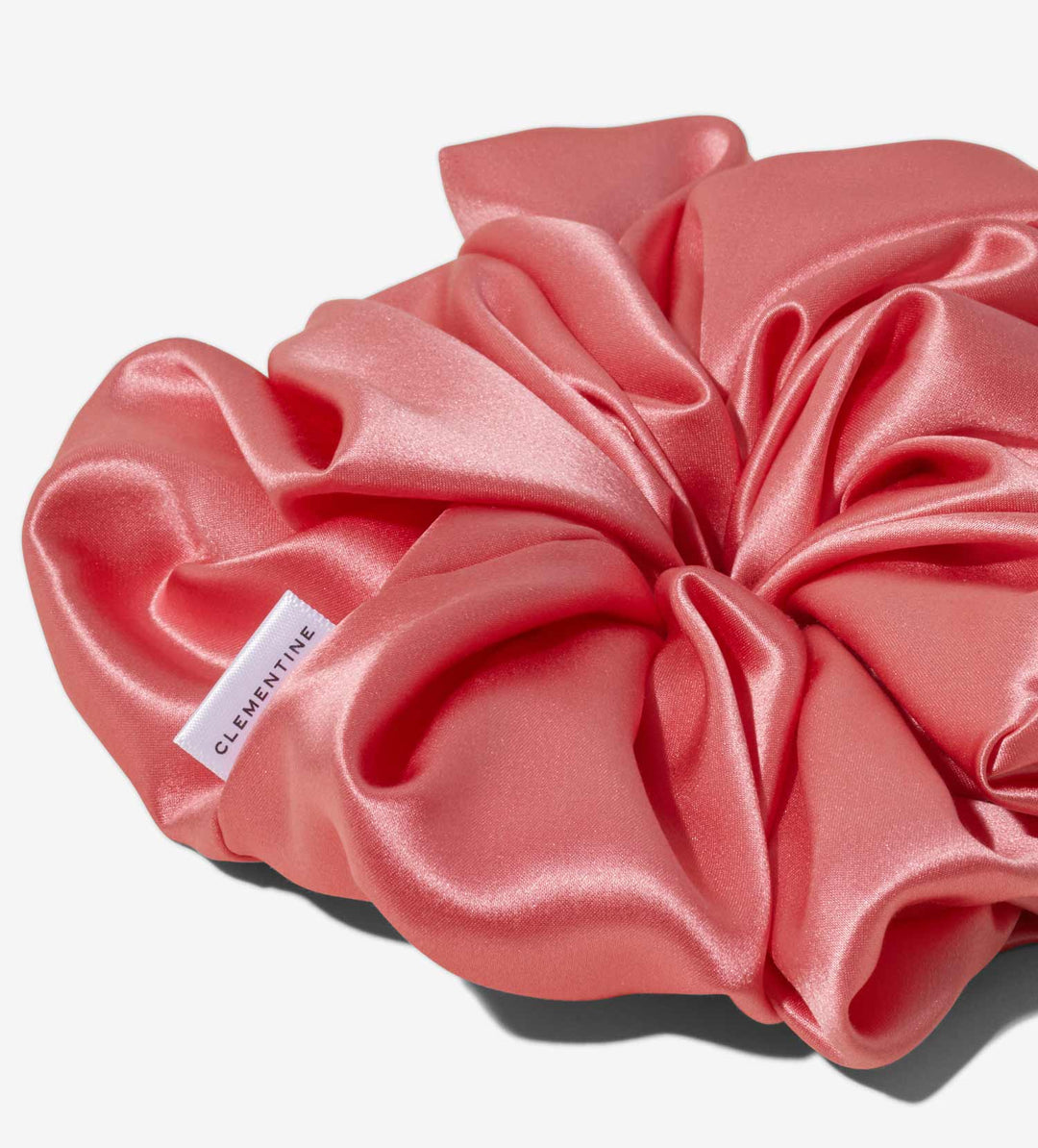 pink silk scrunchie with fabric tag reading CLEMENTINE