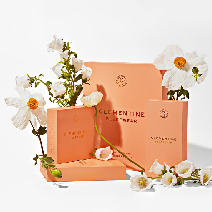Peach packaging with white flowers and the words: CLEMENTINE SLEEPWEAR; SLEEP WITH CLEMENTINE; 100% ORGANIC MULBERRY SILK