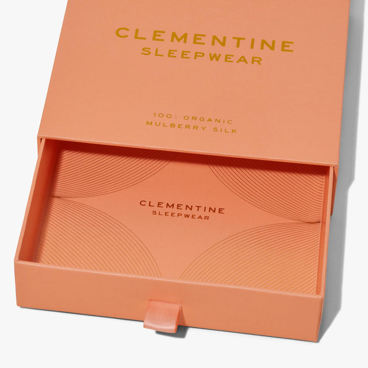 Peach sliding drawer box for CLEMENTINE SLEEPWEAR; interior card shows "CLEMENTINE SLEEPWEAR" and "100% ORGANIC MULBERRY SILK".