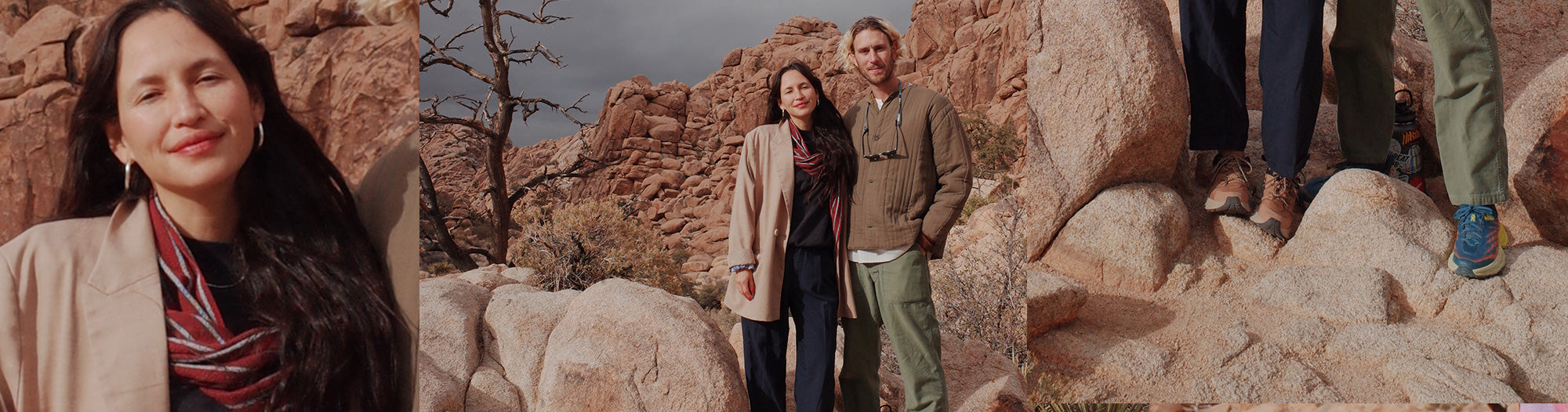 Two people standing on rocks in a desert landscape with cloudy sky, one wearing a beige jacket and scarf, the other in a brown jacket and green pants
