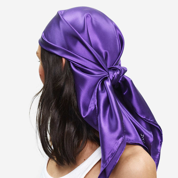 Person wearing a purple satin headscarf on a white background. #color_ultraviolet