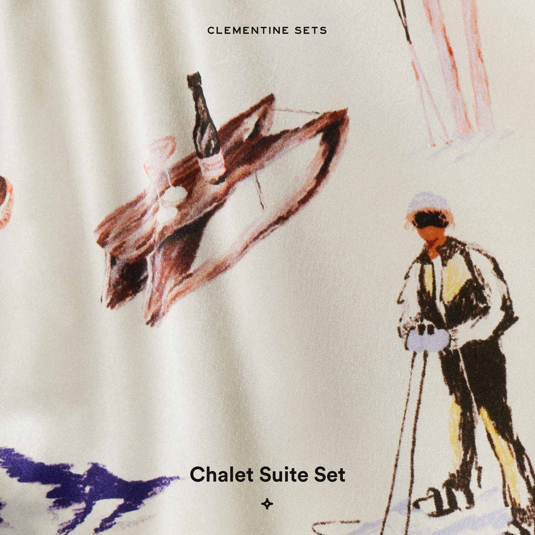 Cream fabric print labeled 'CLEMENTINE SETS' showing a skier and a bottle on a wooden tray; caption 'Chalet Suite Set'.
