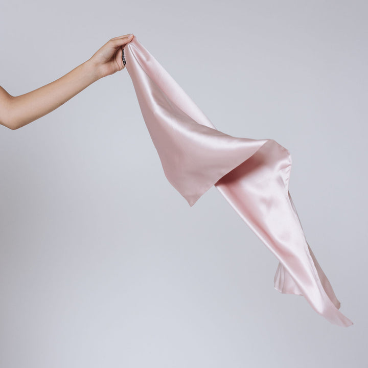 hand holding pink pillowcase#color_pink-sherbert