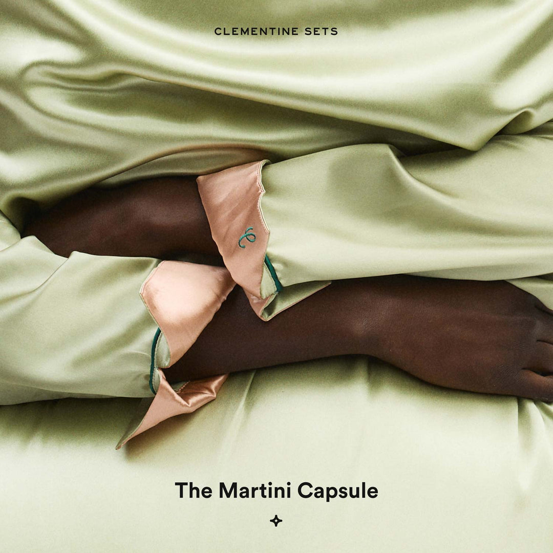 Pale green satin draped over dark-skinned arms showing peach-trimmed cuff; text 'CLEMENTINE SETS' and 'The Martini Capsule'.