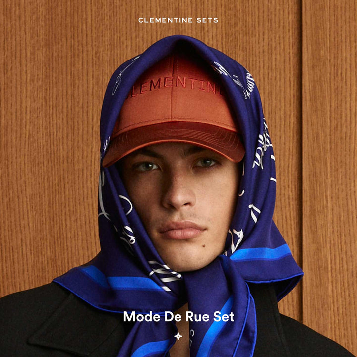 Model wearing orange cap embroidered 'CLEMENTINE', blue scarf with 'CLEMENTINE SETS', and text 'Mode De Rue Set'.