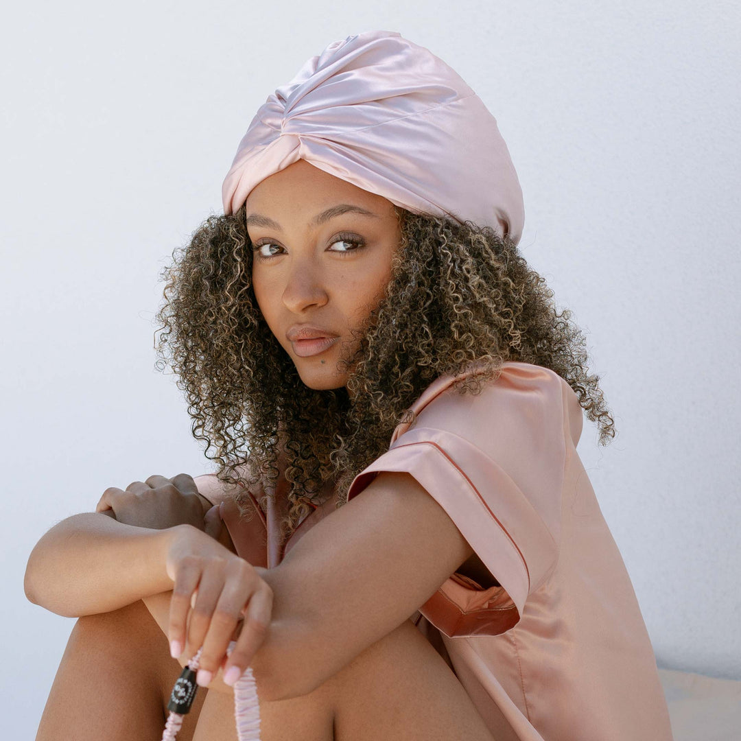 Pink bonnet on thick curly hair outdoors#color_pink-sherbert