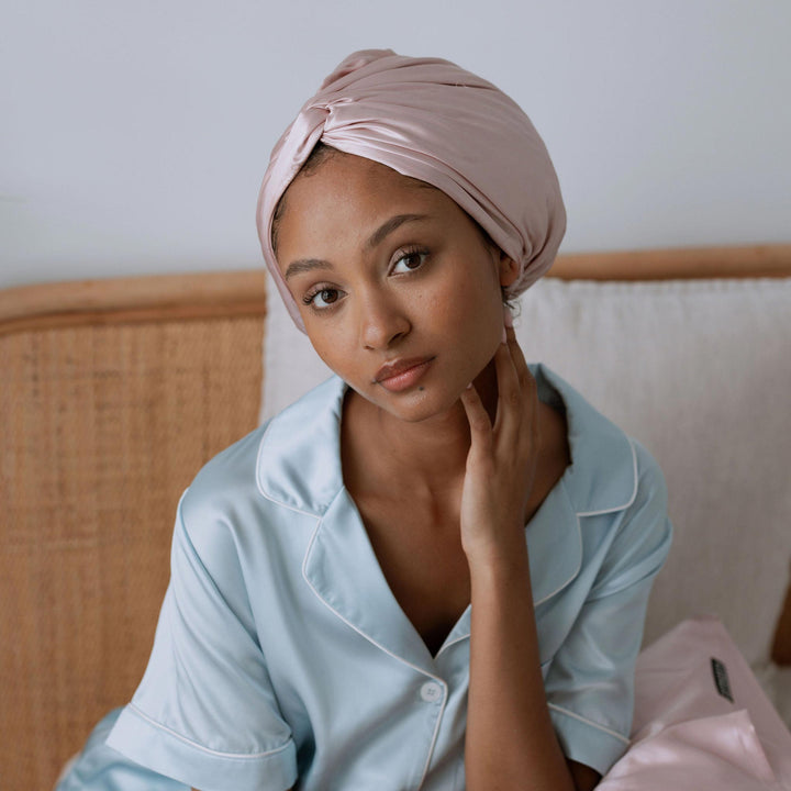 Hair tied up in organic silk hair bonnet in pink indoors#color_pink-sherbert