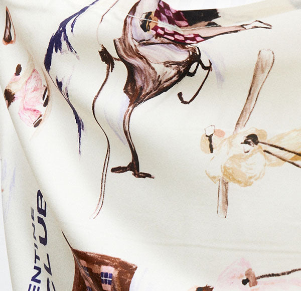 Cream fabric printed with watercolor figures (horses, skiers) and vertical text 'ENTLE' along the left edge.