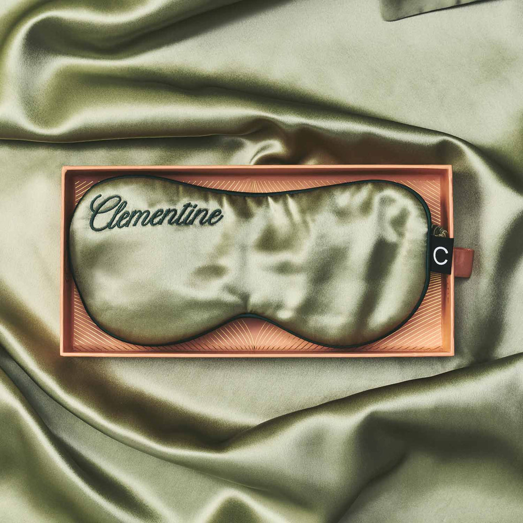 Silk sleep mask in a wooden box on a satin surface with &
