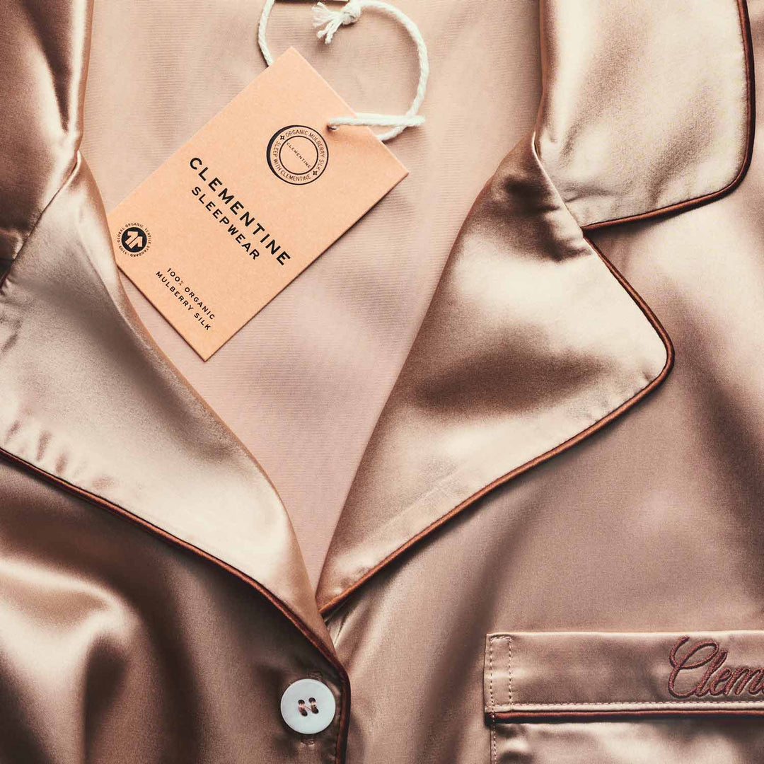 Silky pajama set with a Clementine Sleepwear tag on a matching fabric background. 